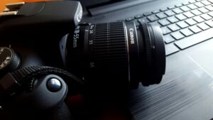 pexels-photo-248519-248519 Close-up of a black DSLR camera with lens on a laptop keyboard.